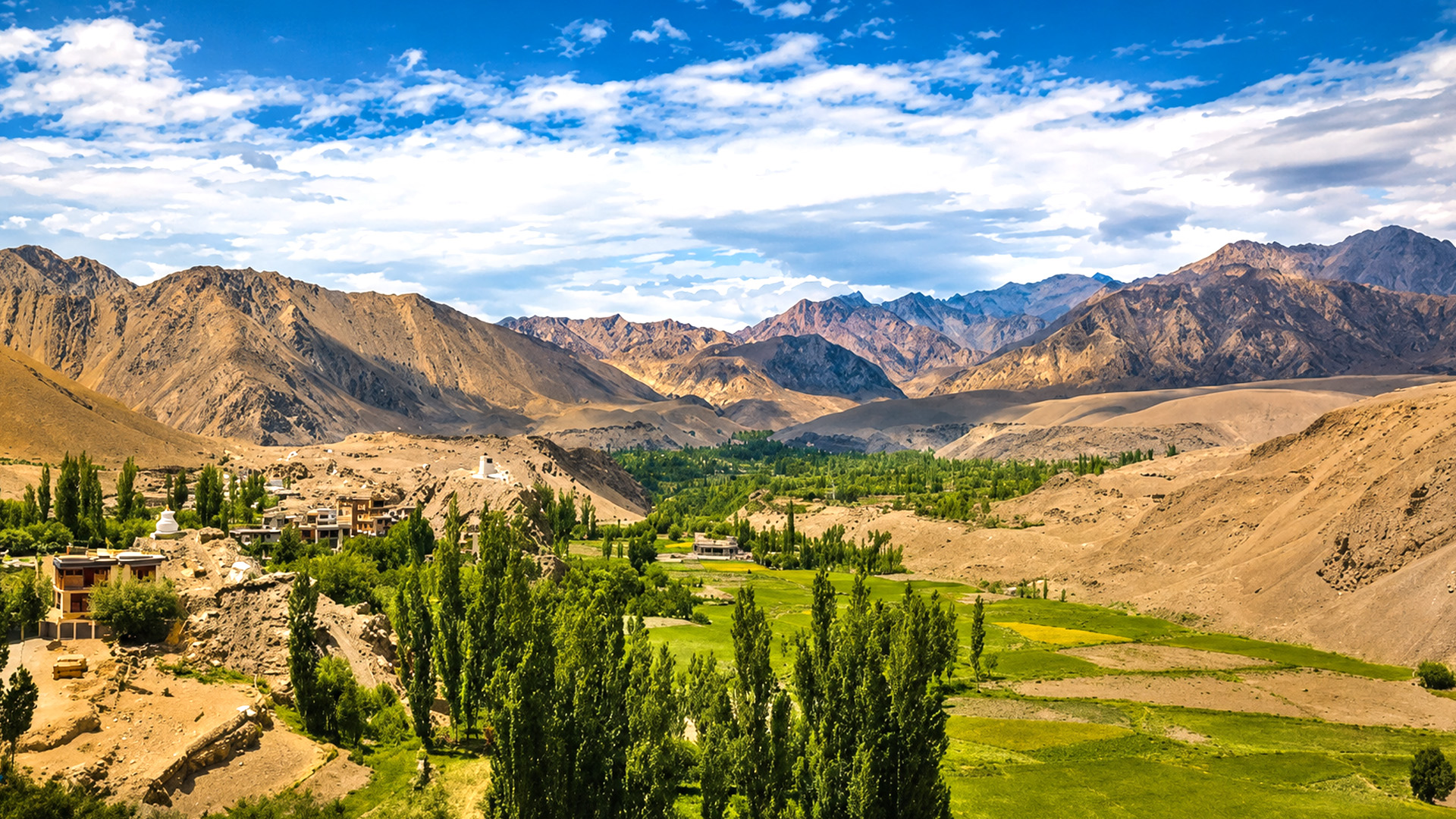 Green valleys beneath the towering Himalayan mountains