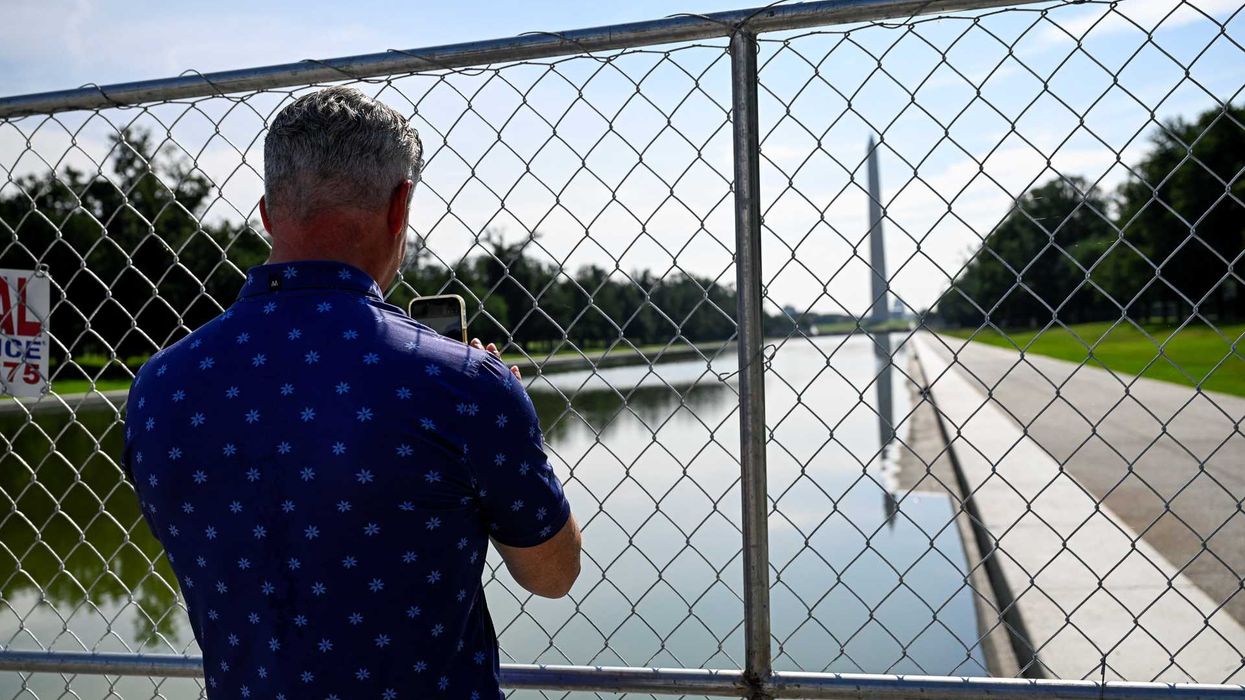 A visitor looks through a fence at the Lincoln Memorial Reflecting Pool on the National Mall in Washington, D.C., U.S., July 11, 2026. REUTERS/Daniel Heuer