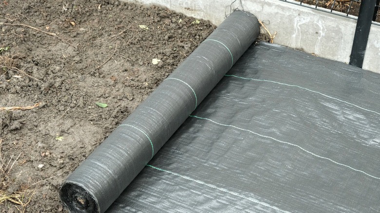 Landscape fabric being put in a planting bed