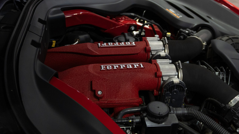 A close-up of a red engine cover on a Ferrari Roma V8.