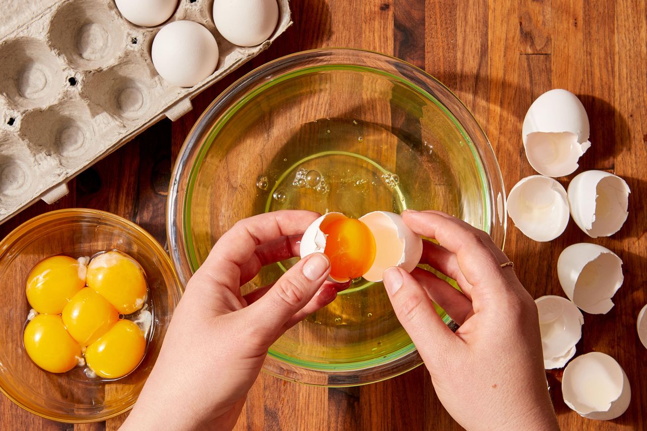 Separating egg white and yolk over bowl