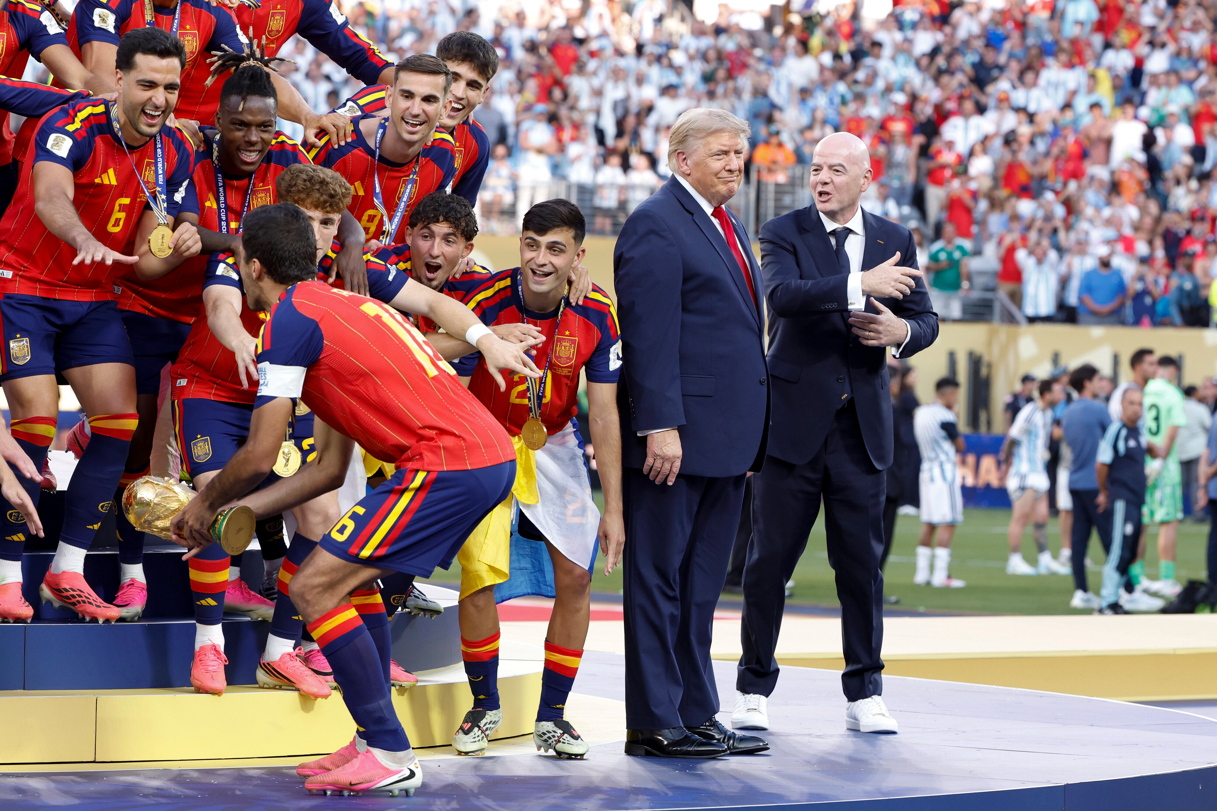 EAST RUTHERFORD, NEW JERSEY - JULY 19: Rodri #16 of Spain lifts the trophy while US President Donald Trump and FIFA President Gianni Infantino look on during the trophy ceremony following the FIFA World Cup 2026 Final football match between Spain and Argentina at New York New Jersey Stadium on July 19, 2026 in East Rutherford, New Jersey. (Photo by Jean Catuffe/Getty Images) (Photo: Jean Catuffe via Getty Images)