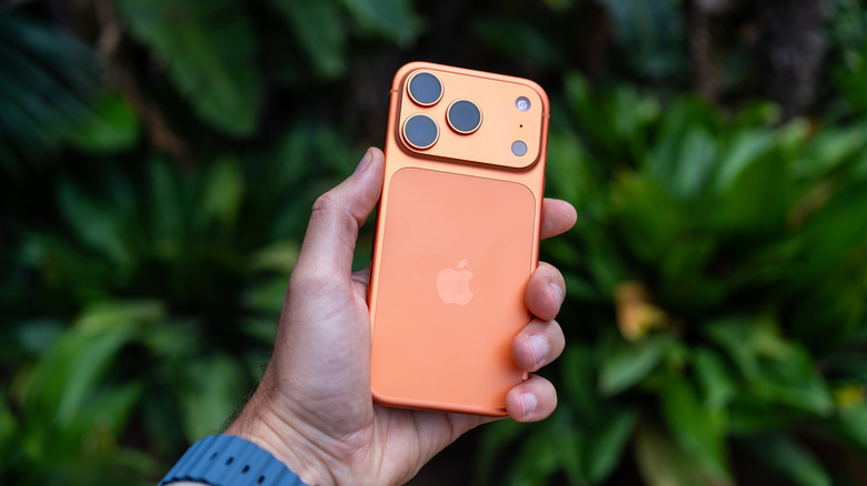 Person holding an orange iPhone 17 Pro