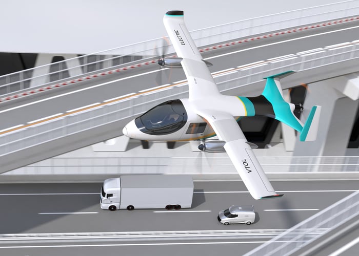 An eVTOL aircraft flying above a highway.