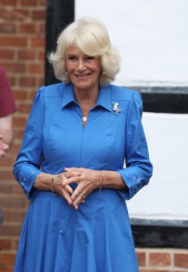 Queen Camilla wears Van Cleef & Arpels Lucky Spring butterfly clip at the Emmaus Norfolk and Waveney charity, which offers a home, work opportunities and support to people experiencing homelessness on July 20 in Bungay, England.