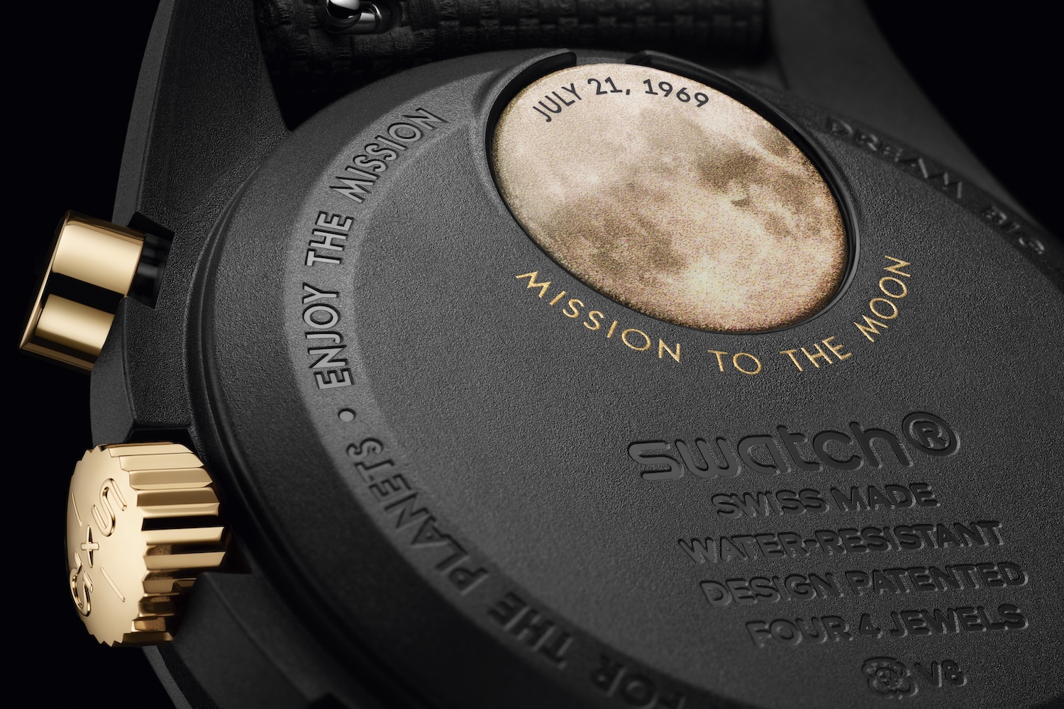 a black watch caseback with a gold moon inscription.