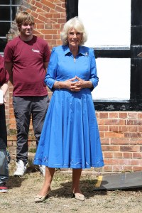 Queen Camilla wears Van Cleef & Arpels Lucky Spring butterfly clip at the Emmaus Norfolk and Waveney charity, which offers a home, work opportunities and support to people experiencing homelessness on July 20 in Bungay, England.