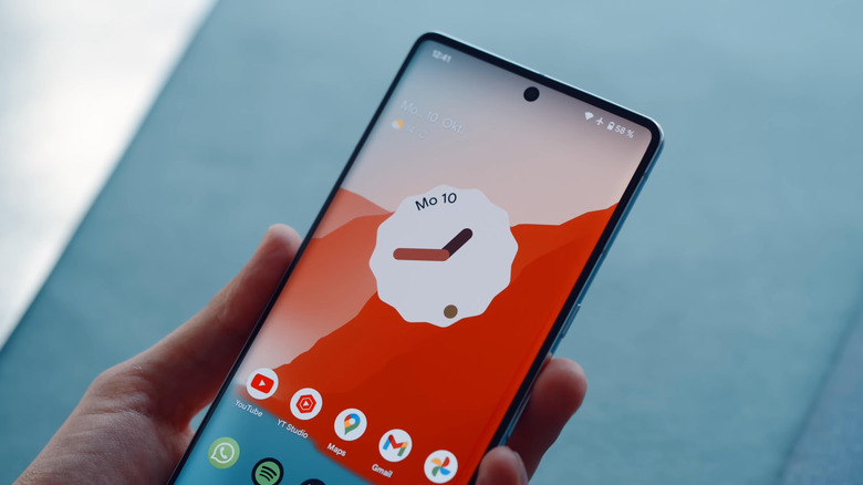 Pixel held in hand showing home page of Pixel Launcher