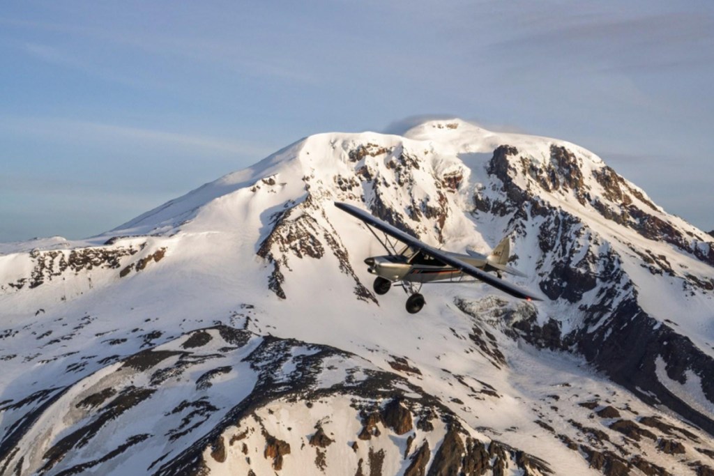 Air-to-air: the turbine-powered Carbon Cub ULT flies near the snow-capped peak of Mount Adams during flight testing. [Credit CubCrafters]