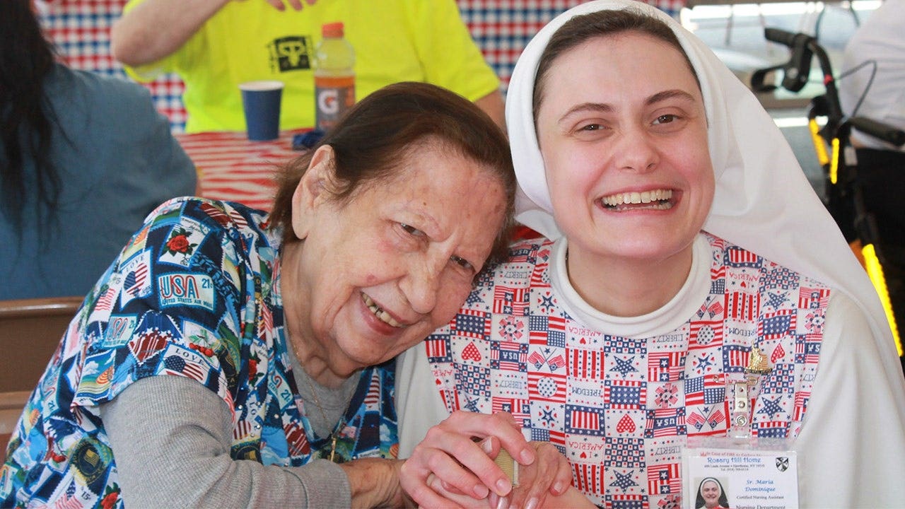 A Dominican Sister of Hawthorne hugs a resident.