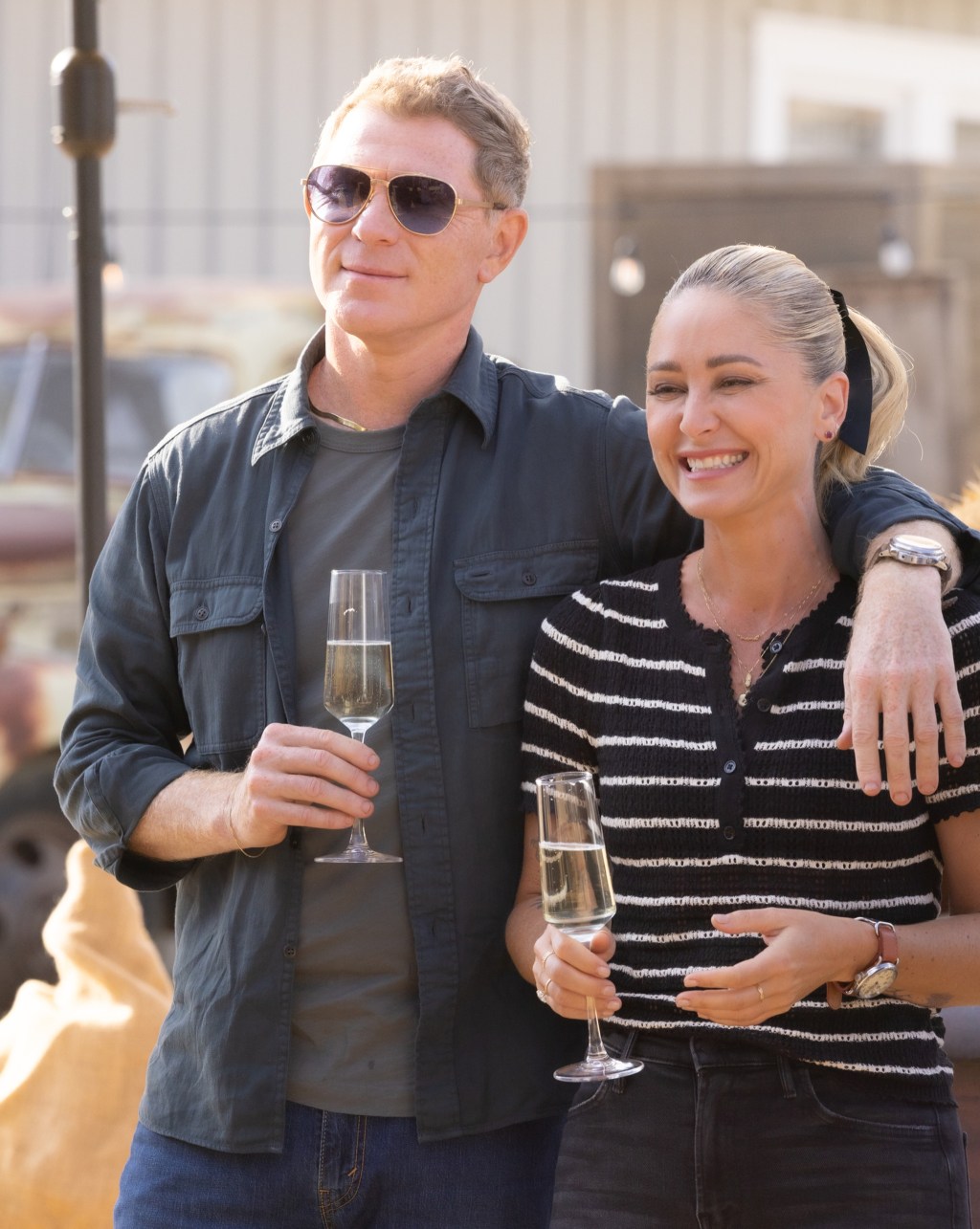 Bobby Flay and Brooke Williamson clinking champagne glasses.