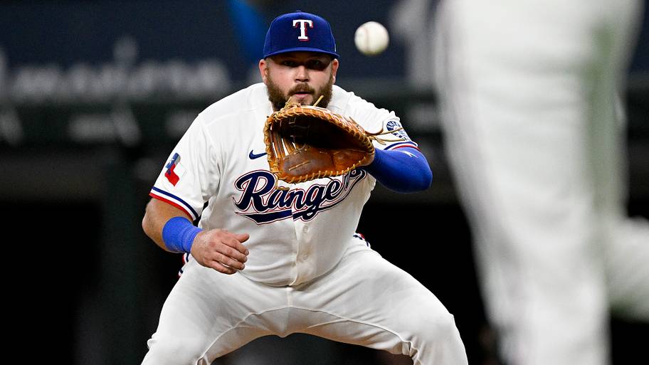 Texas Rangers first baseman Jake Burger prepares to catch a baseball with his glove.