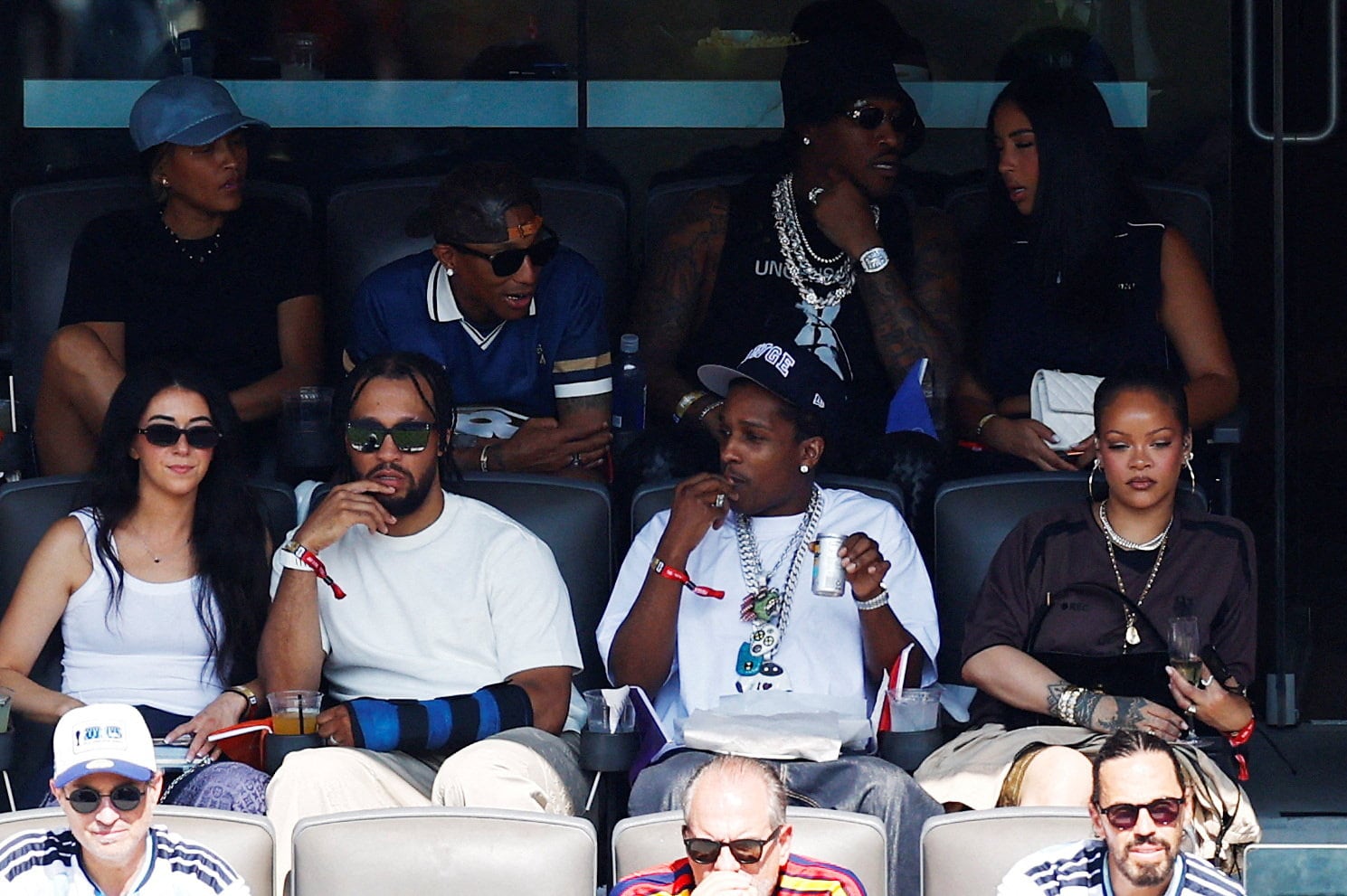 Singer Rihanna appears with boyfriend and rapper ASAP Rocky, while musician Pharrell Williams speaks to him from a row above in the stands during the World Cup final. / Jeenah Moon / REUTERS