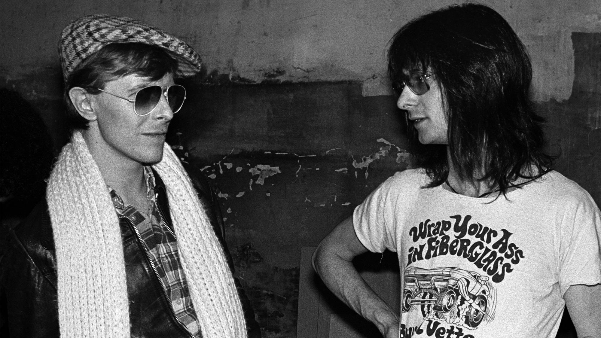 David Bowie (left) poses with Lenny Kaye, from the Patti Smith Group, at CBGB's club in New York City on April 04 1975