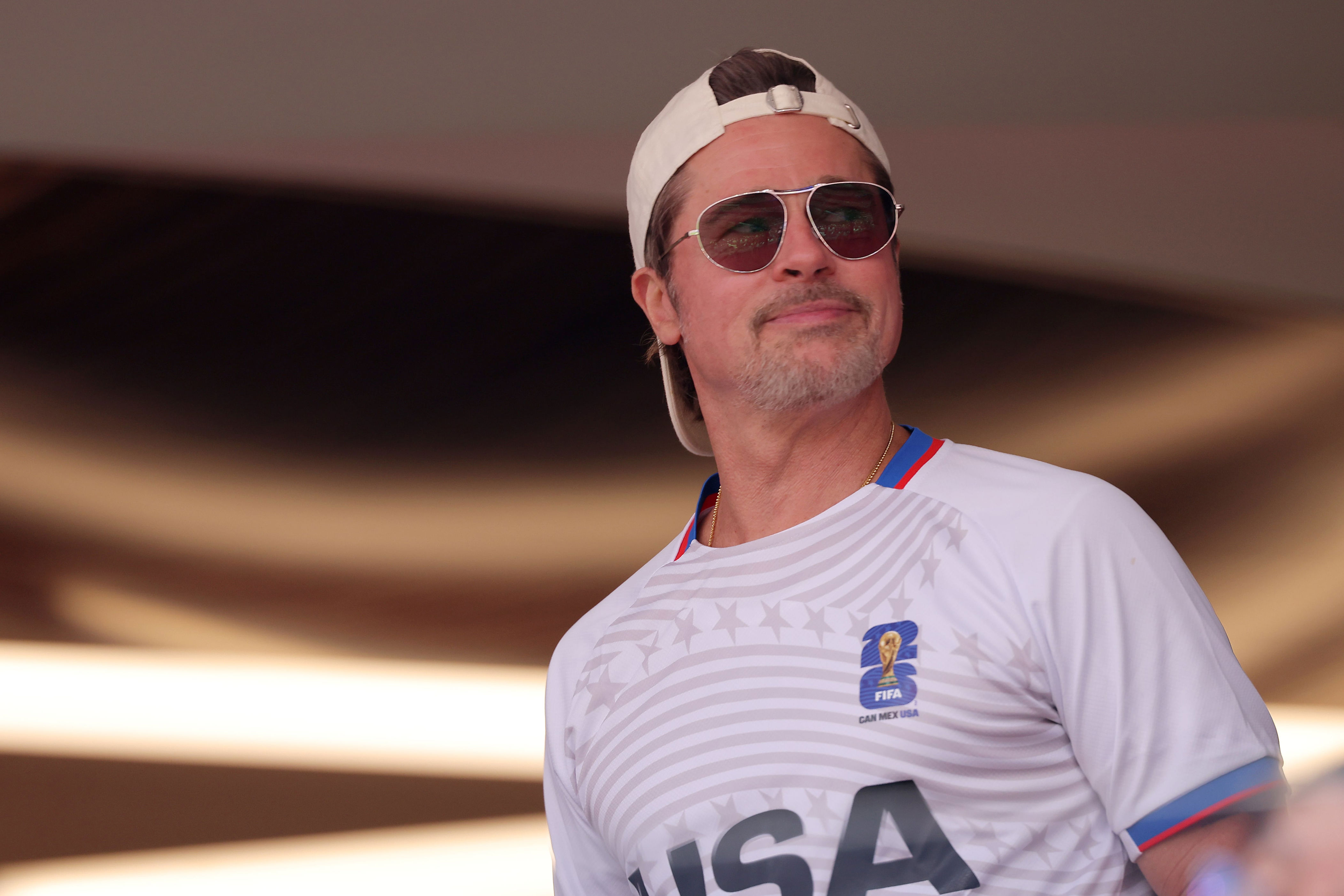 Brad Pitt looks on during the FIFA World Cup 2026 quarterfinal match between Spain and Belgium, wearing a backward hat and his aviator sunglasses. / Katelyn Mulcahy - FIFA/FIFA / Getty Images