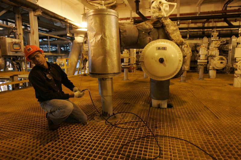 A worker adjusts a cable in the well bay of Chevron's Petronius oil platform in the Gulf of Mexico