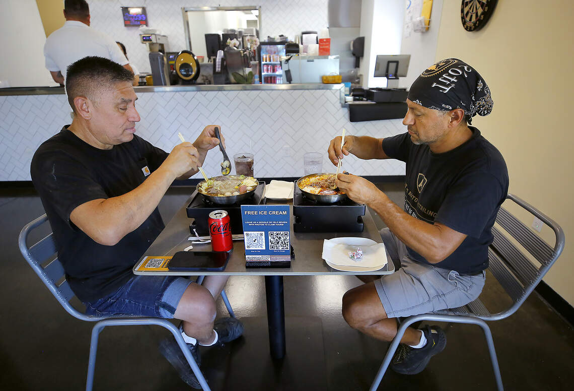 Regular customers Alfredo Flores of Pasco, left, and Arturo Nuez of Kennewick enjoy their hot soup bowls recently for lunch at the Flavorjoy restaurant in Richland.