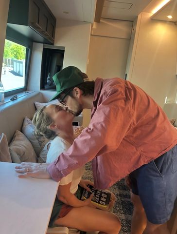 Hilary Duff and her husband Matthew Koma kiss in a photo from her tour