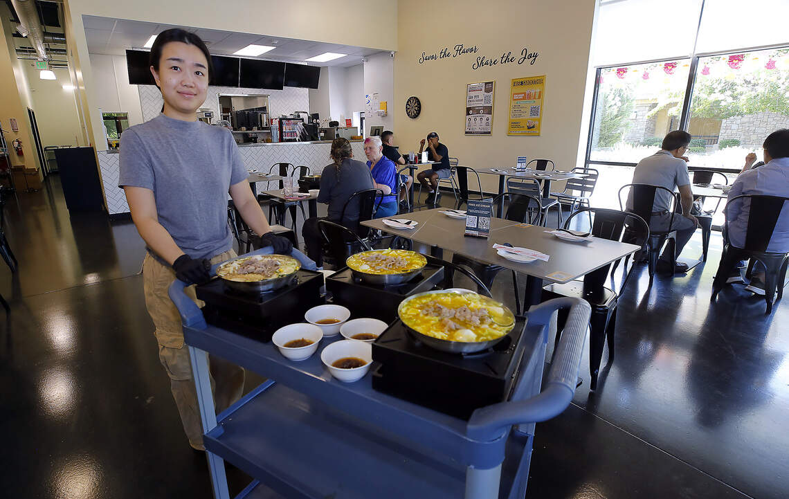 Jiao Wu, co-owner of FlavorJoy restaurant, serves lunch customers hot soup bowls recently at the Richland restaurant on George Washington Way.