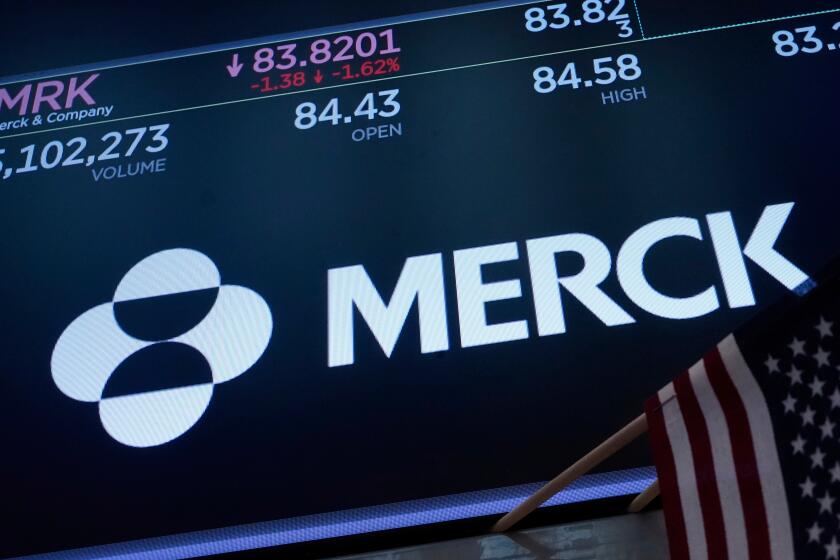 The logo for Merck appears above a trading post on the floor of the New York Stock Exchange.