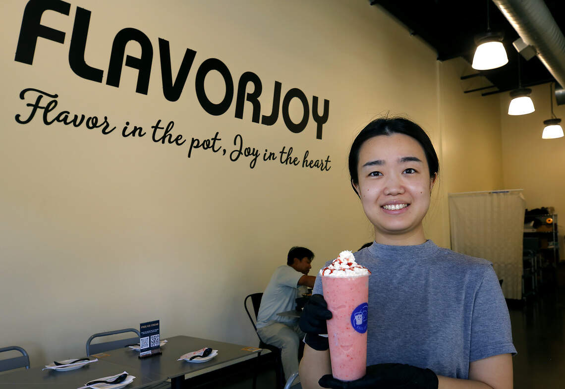 Jiao Wu, co-owner of FlavorJoy restaurant, holds a strawberry smoothie offered on the menu of the Richland restaurant on George Washington Way.