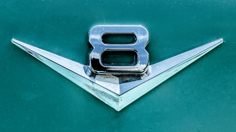A close-up of a vintage muscle car V8 emblem.