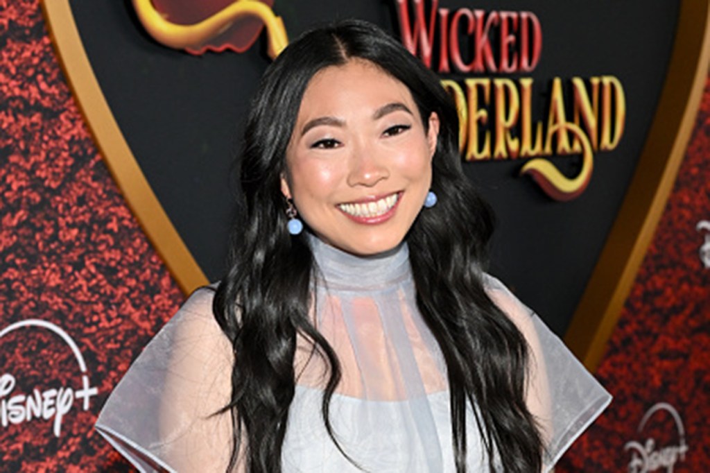 Awkwafina smiling at the camera, wearing a light blue dress.