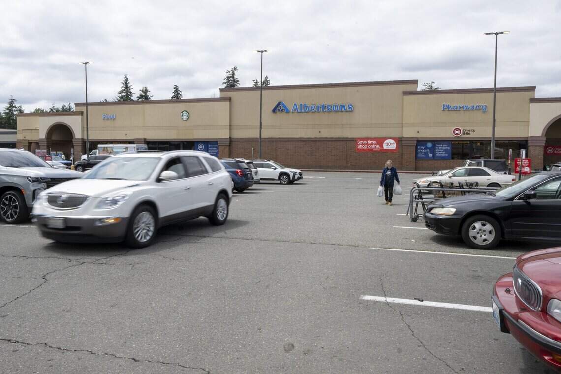 Shoppers move across the parking lot of Albertsons at the Summit Country shopping center on Friday, July 17, 2026, in Puyallup. The parcel of land that the store and its parking lot sits on recently sold.