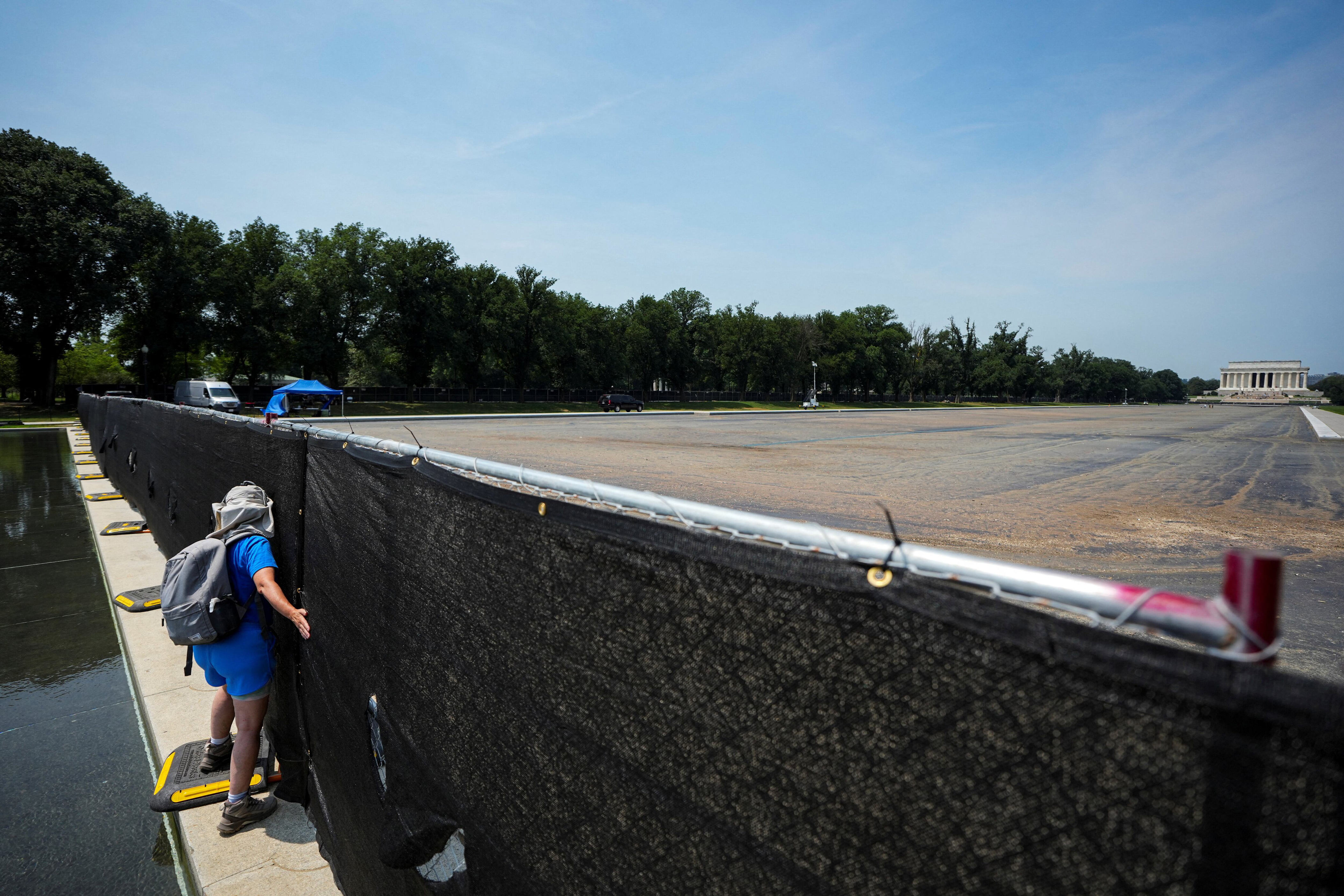After the renovation spiraled into a fiasco, the Reflecting Pool was cordoned off behind a fence, which was later covered with a black tarp. / Al Drago/Reuters