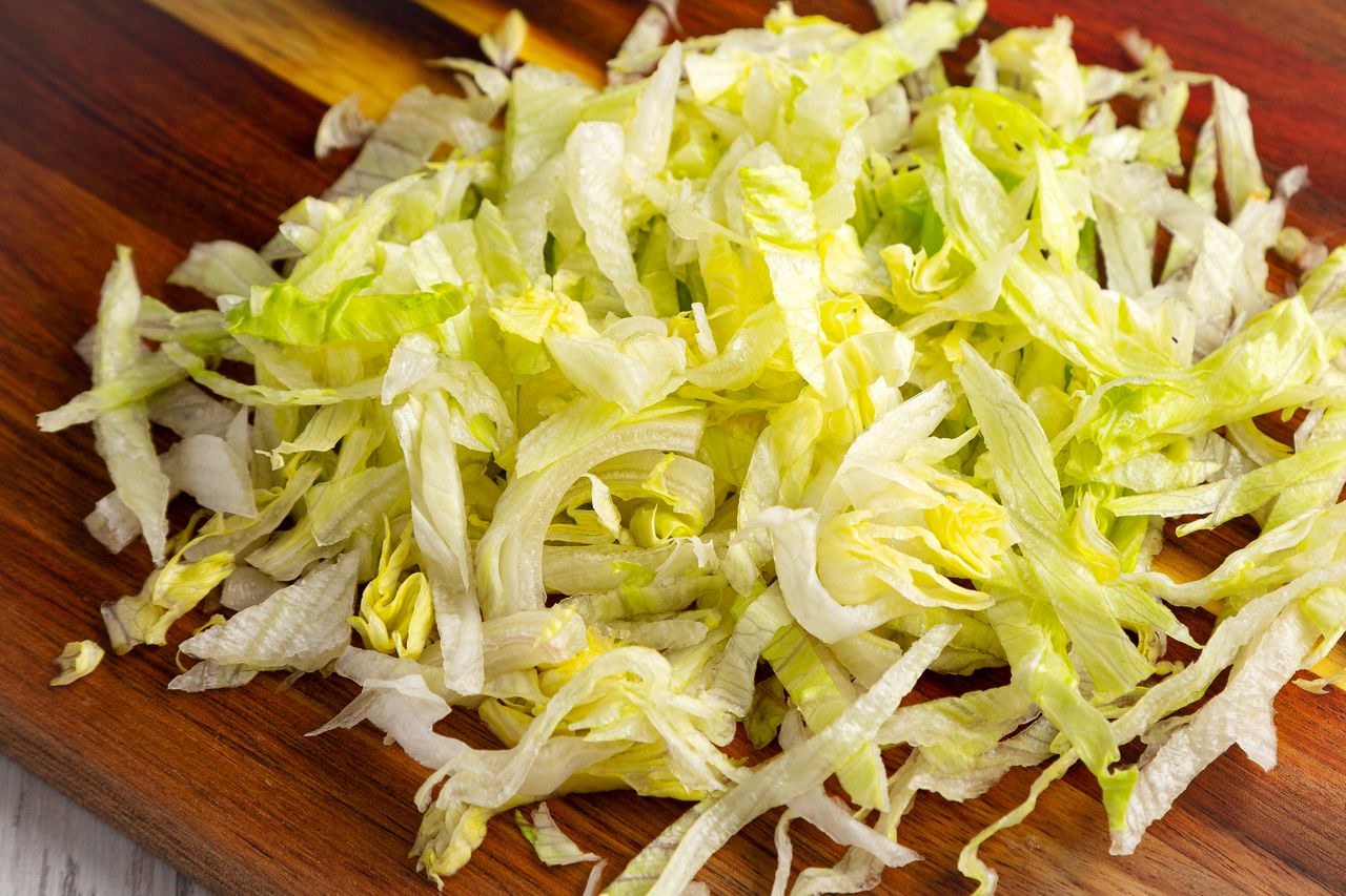 Shredded iceberg lettuce on a wooden surface