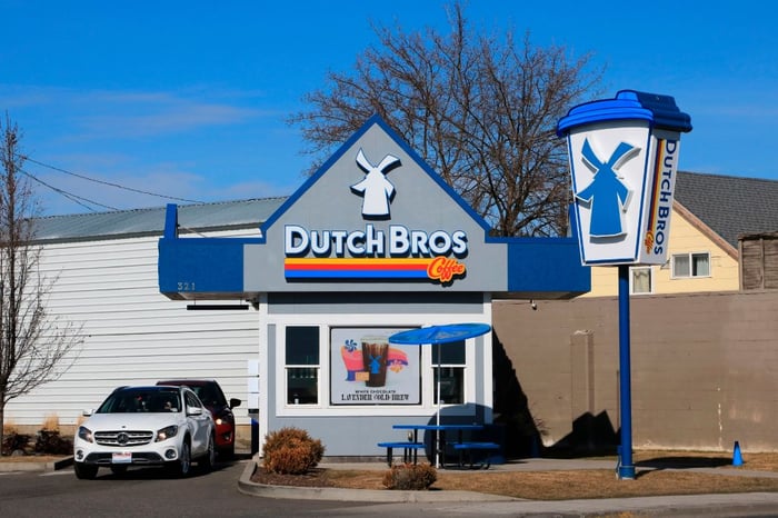 A Dutch Bros location with cars waiting at a drive-thru window.