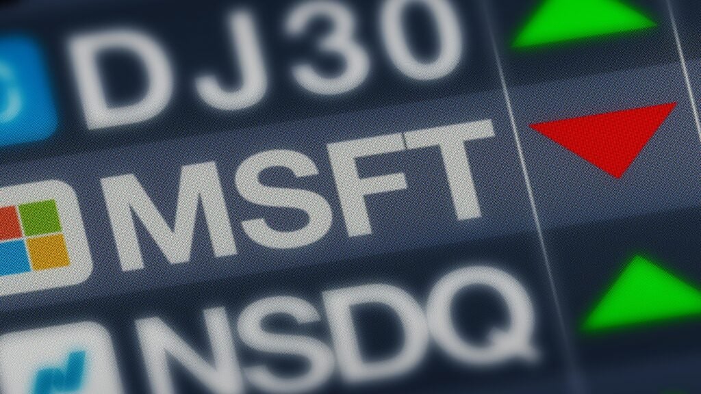 Digital stock screen displays MSFT (Microsoft) with a red downward arrow, indicating a decline.