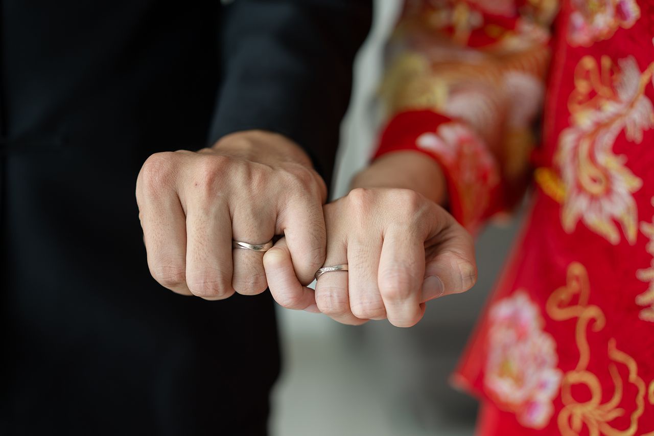 Stock image of a couple showing their hands with wedding rings