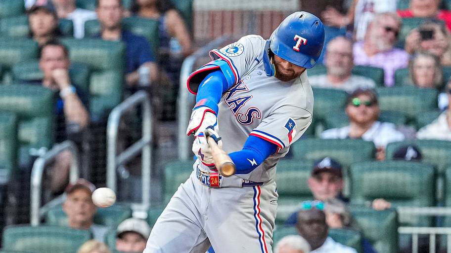 Texas Rangers right fielder Brandon Nimmo swings his bat at a baseball during a game.