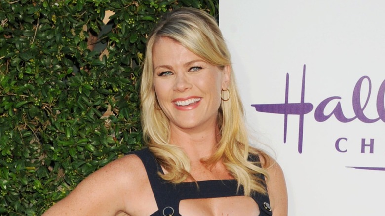 Alison Sweeney poses in a black sleeveless dress with her blond hair down in loose waves on the red carpet at the Summer TCA Tour for Hallmark Channel and Hallmark Movies and Mysteries in Beverly Hills in July 2015.