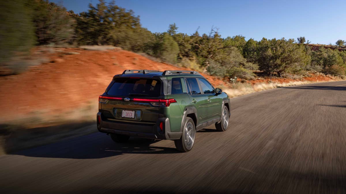 2026-subaru-outback-in-deep-emerald-green-rear-angled-view-driving