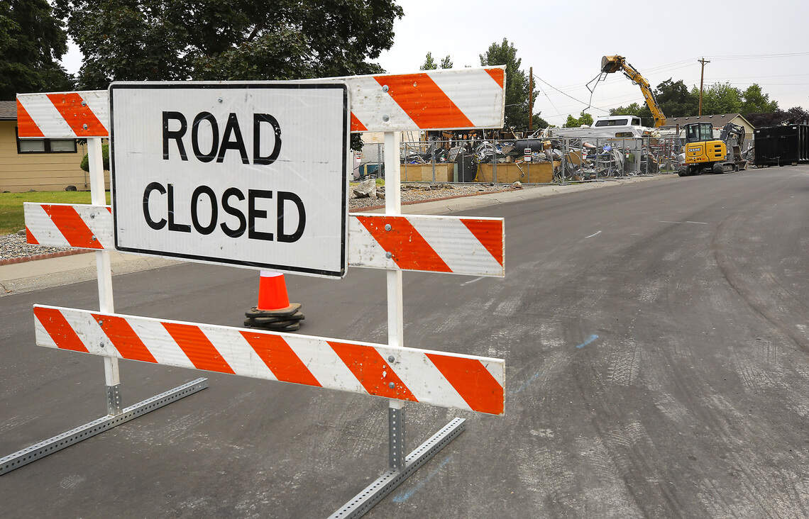 Barricades temporaily block the roady, as an excavator operated by a local contractor hired by the city of Richland begins cleanup and removal Monday morning of junk, vehicles and debris from 2100 Pullen Street in Richland.
