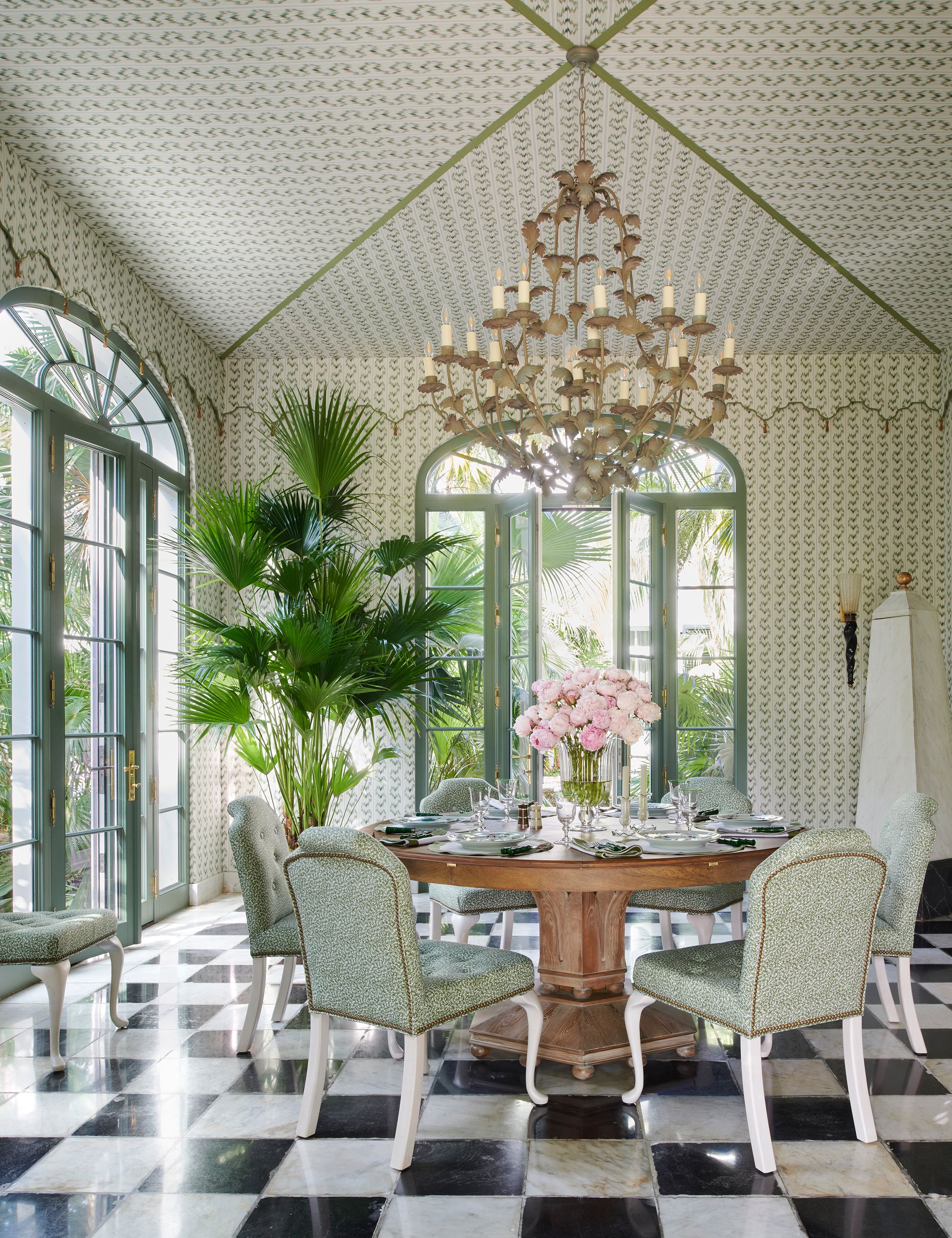 A tented dining room at one corner of the house functions as an indoor breakfast room as well as an outdoor space when the doors are open. Leah O’Connell printed fabric covers the ceiling and walls, creating the impression of a pleasure tent in contrast with the more formal, original checkered marble floor. Taylor King chairs upholstered in a Holly Hunt fabric surround the Woodbridge dining table.