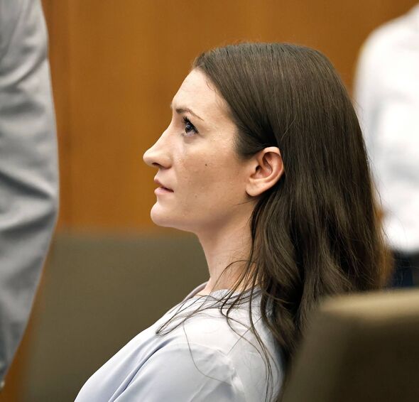 A woman with long brown hair in a courtroom