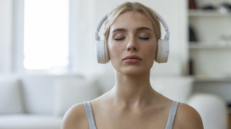 A person listening to headphones with their eyes closed