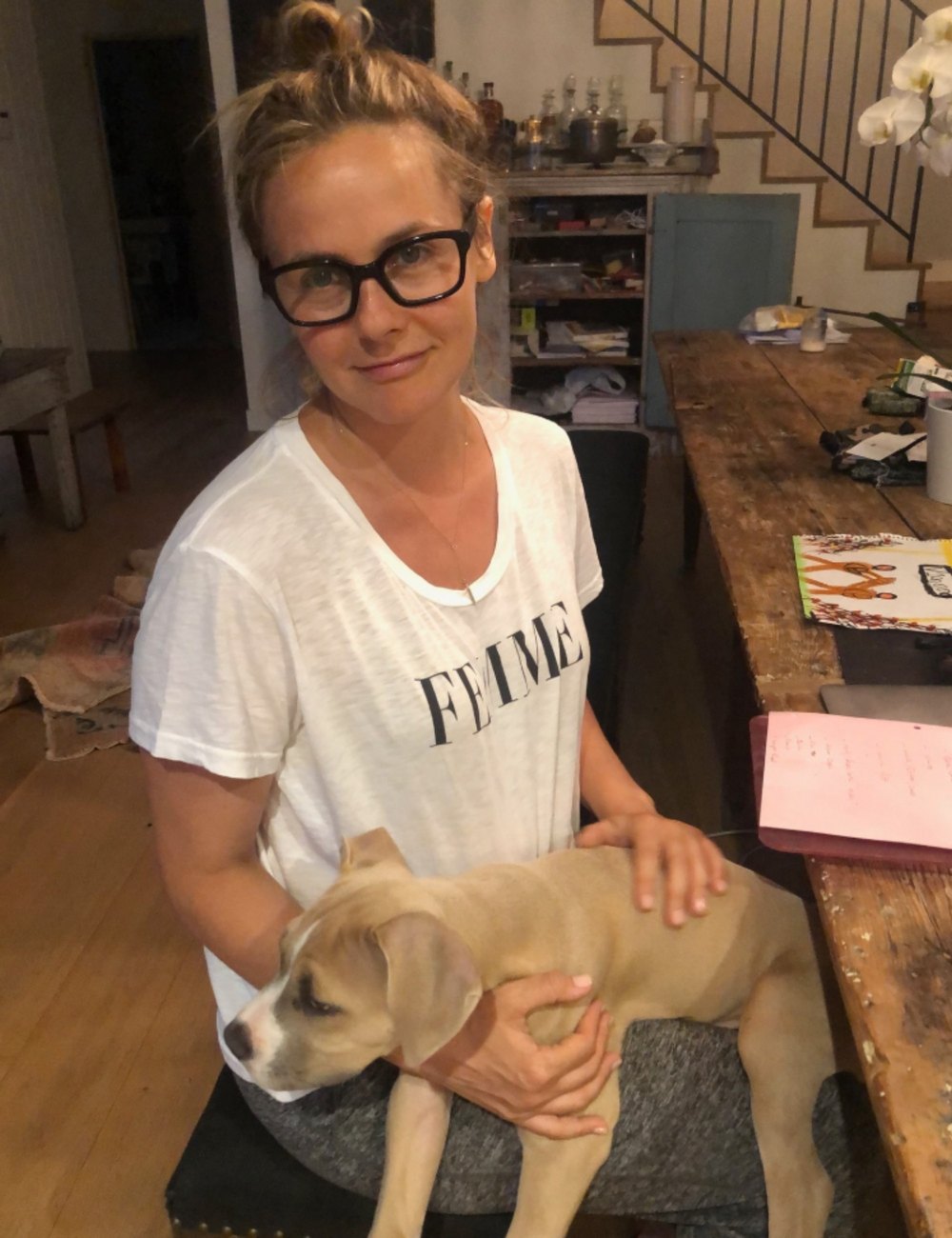Alicia Silverstone poses for a photo with her dog inside the living room of her Los Angeles home
