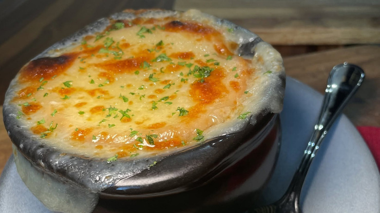French onion soup from Outback, covered with cheese and herbs in a black bowl