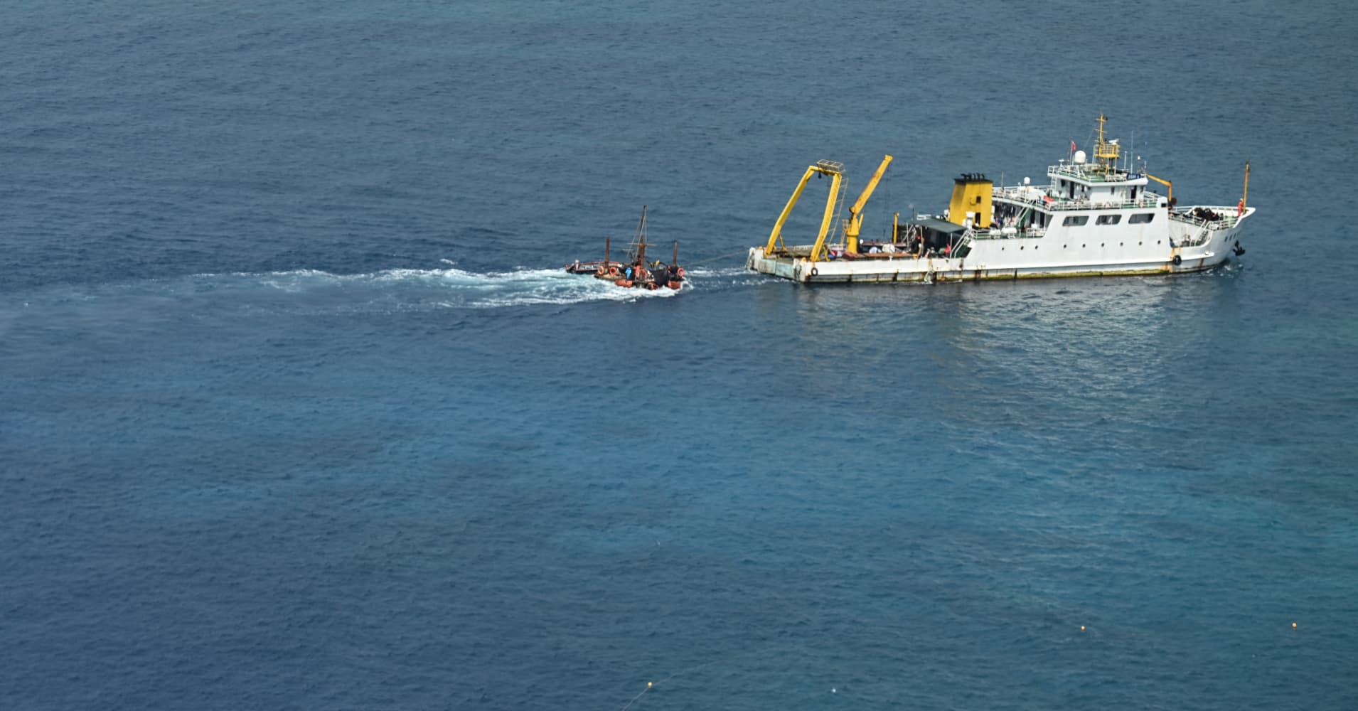 A ship identified by the Philippine Coast Guard as a Chinese research vessel is seen towing a floating structure at Scarborough Shoal in the disputed South China Sea on June 15, 2026.