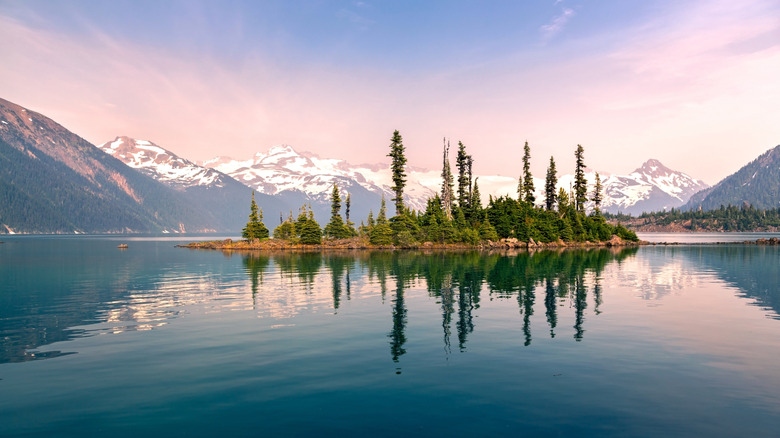 Battleship Island with pine trees reflected in calm water of Garibaldi Lake, British Columbia Canada