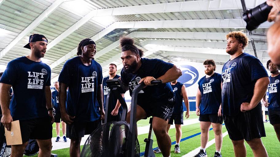 Penn State Nittany Lions defensive lineman Siale Taupaki competes in an exercise bike race during the 23rd Lift for Life.