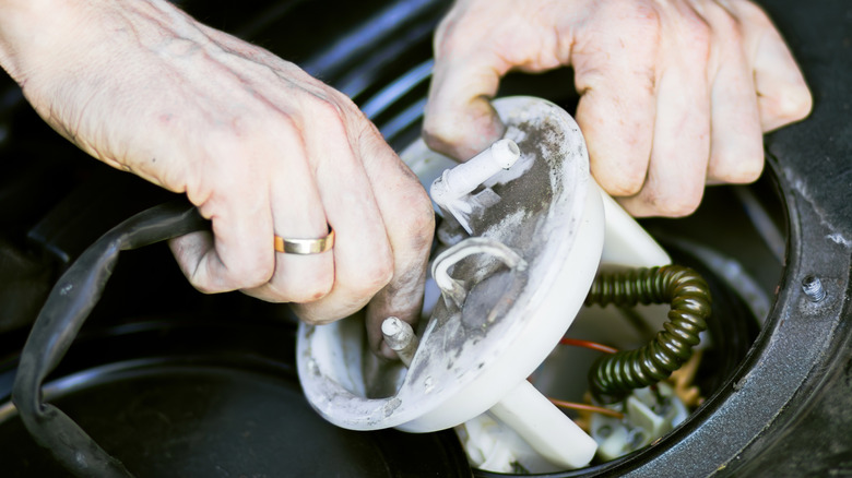 Close-up of technician installing fuel pump