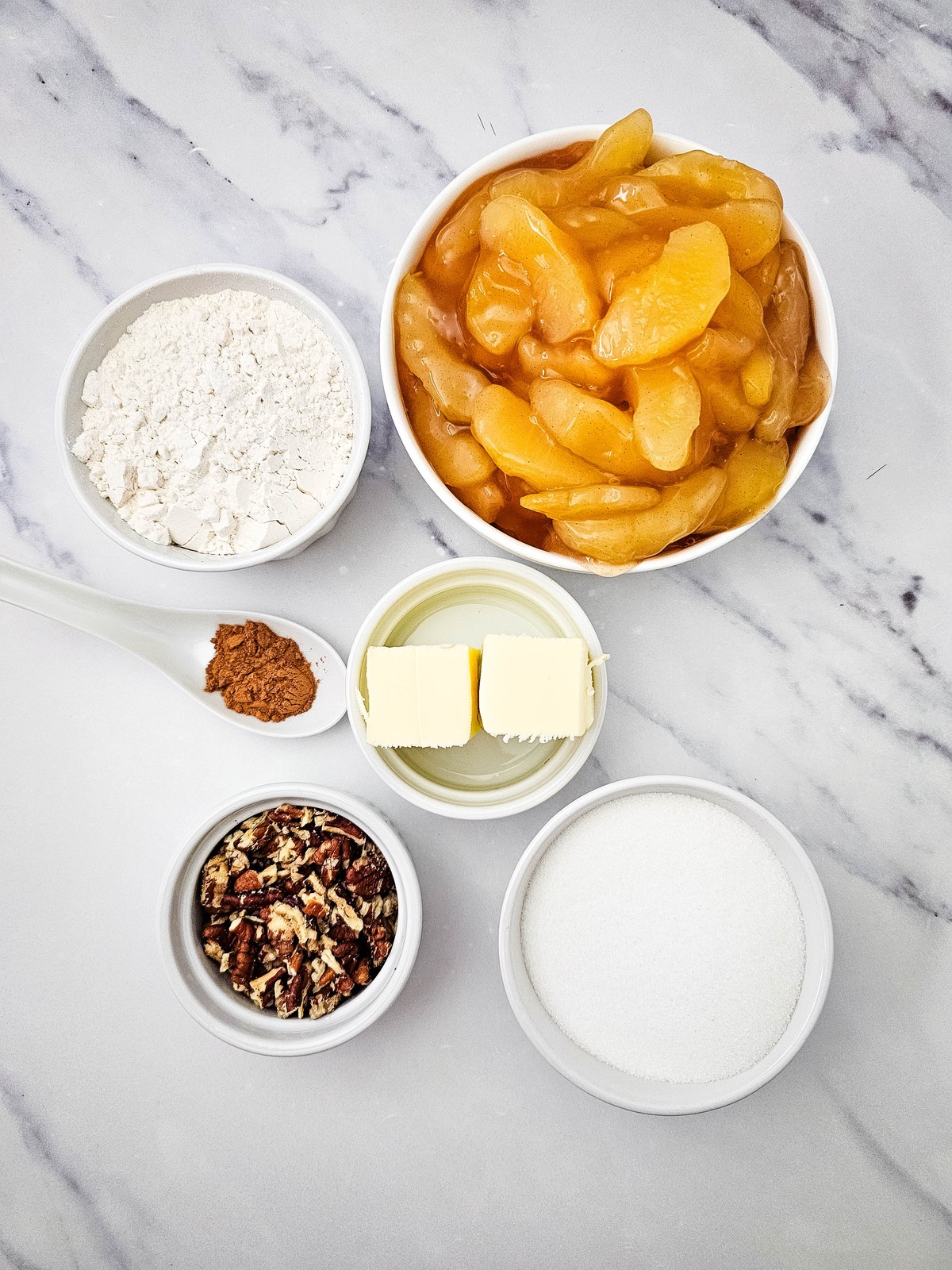 Apple crisp ingredients: apple pie filling, flour, sugar, butter, cinnamon and pecans