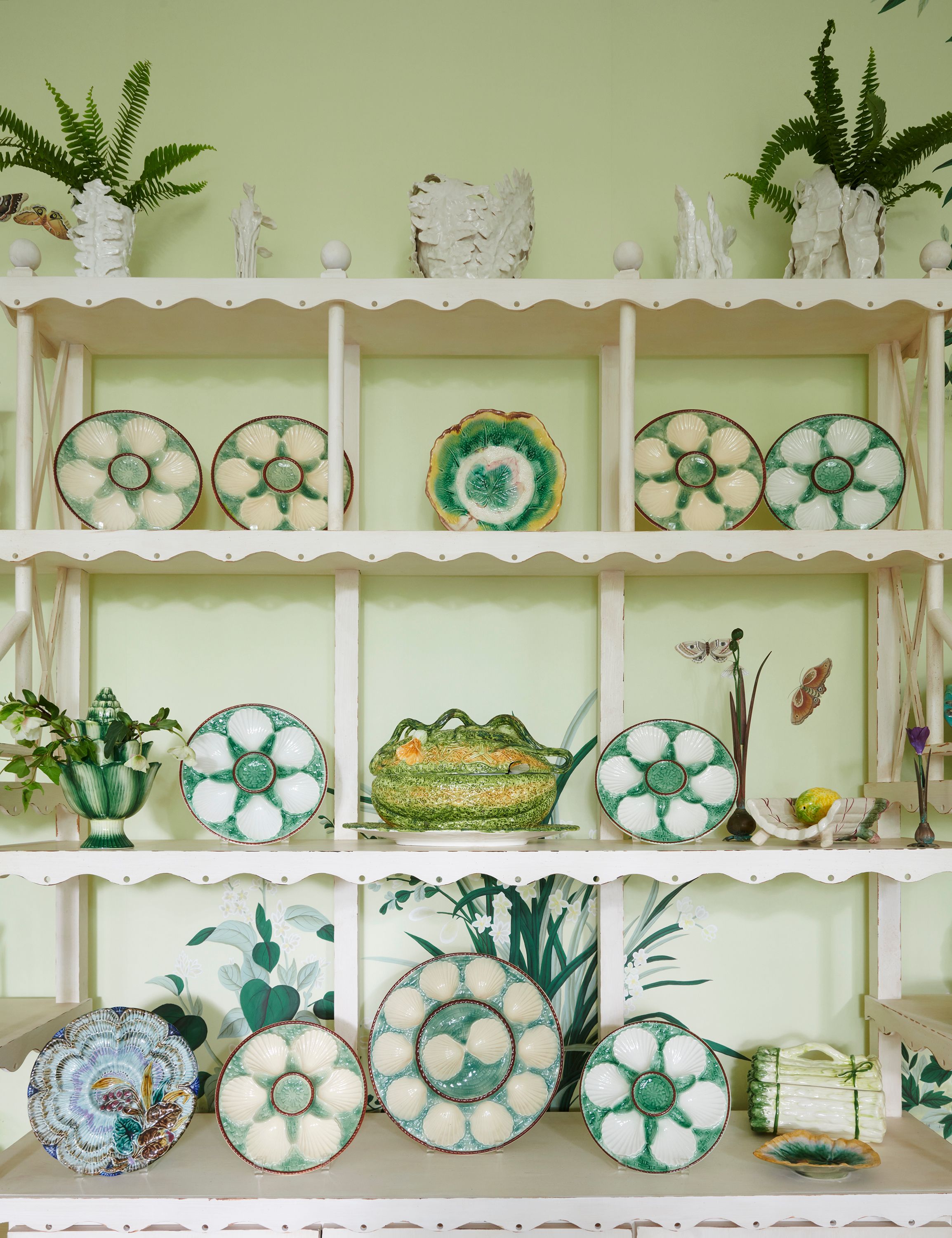 Arranged on white shelves in the family room, majolica from Chairish and 1stDibs take pride of place.