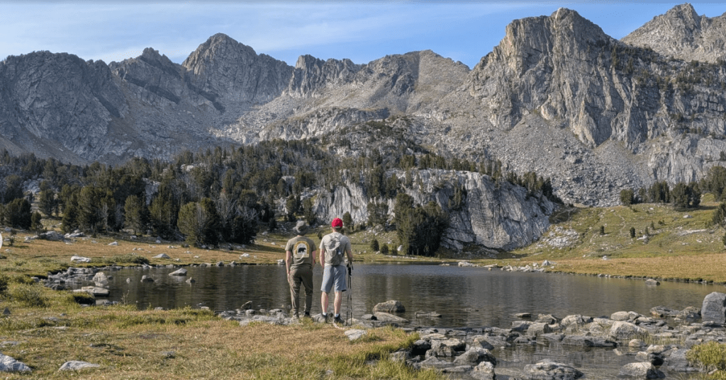 Two hikers stop to admire the mountain scenery along the Beehive Basin Trail in Montana.