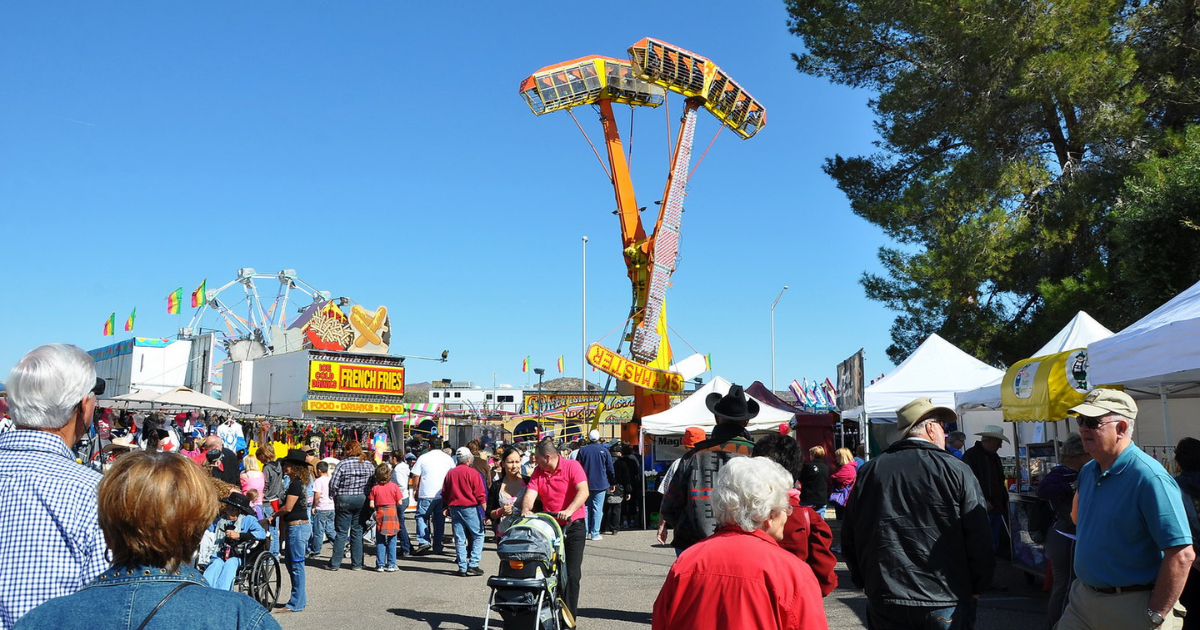 Crowds explore carnival rides, food vendors, and festival booths during Gold Rush Days in Wickenburg, Arizona.